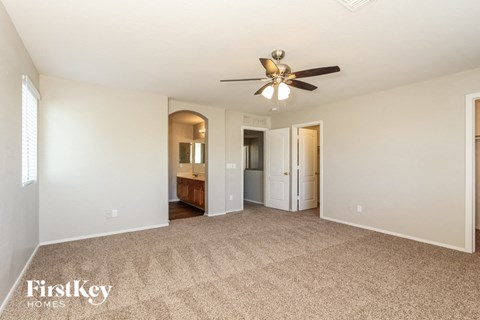 a living room with carpet and a ceiling fan