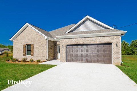 A house with a garage door and a driveway in front of it.