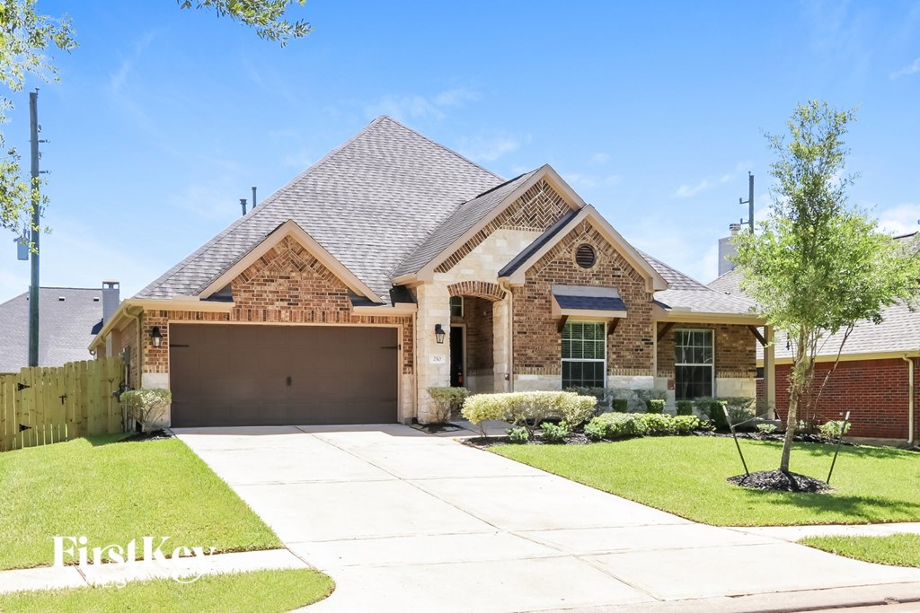 A house with a brick facade and a large driveway.