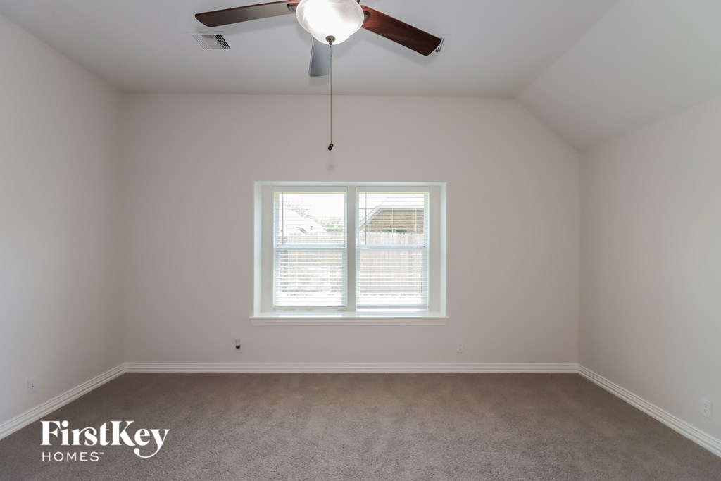 A room with a window and a ceiling fan.