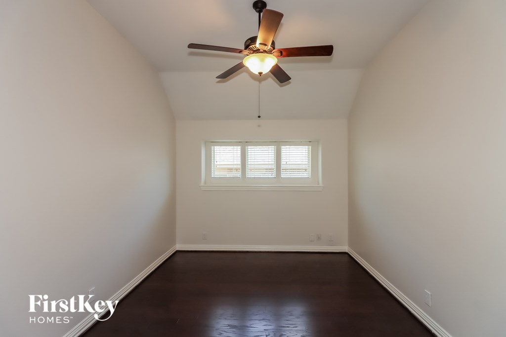 A room with a ceiling fan and a window.