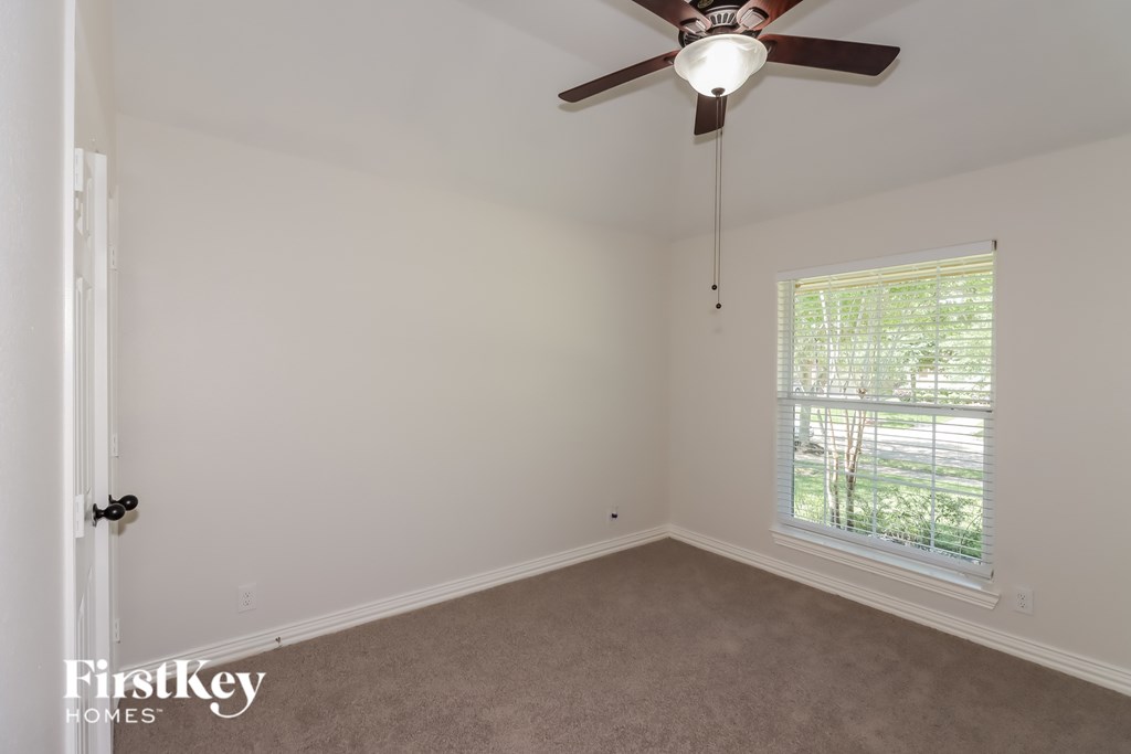 A room with a ceiling fan and a window.