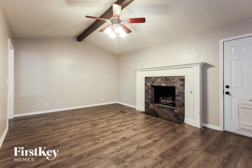 a living room with a fireplace and a ceiling fan