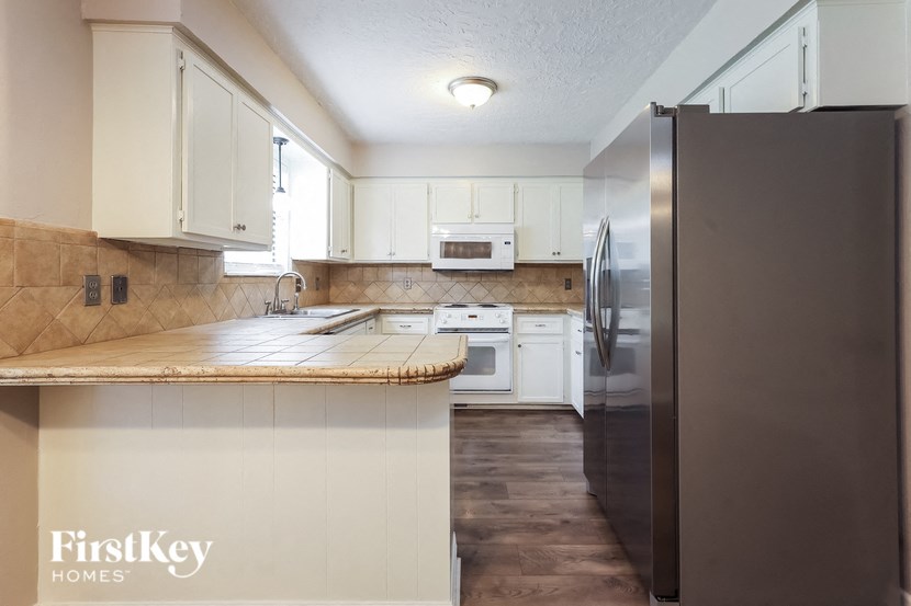 a kitchen with white cabinets and stainless steel appliances