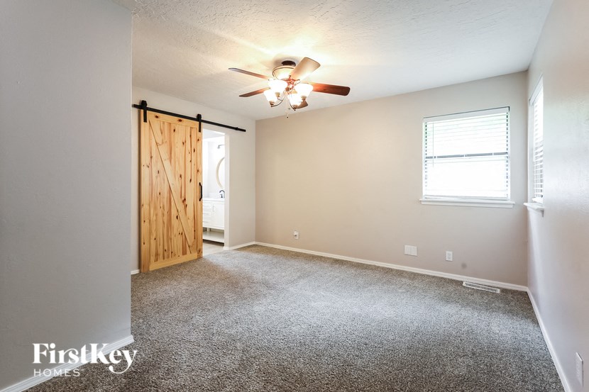 the master bedroom is spacious and has a closet and a ceiling fan