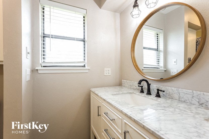 a bathroom with a sink and a mirror and a window
