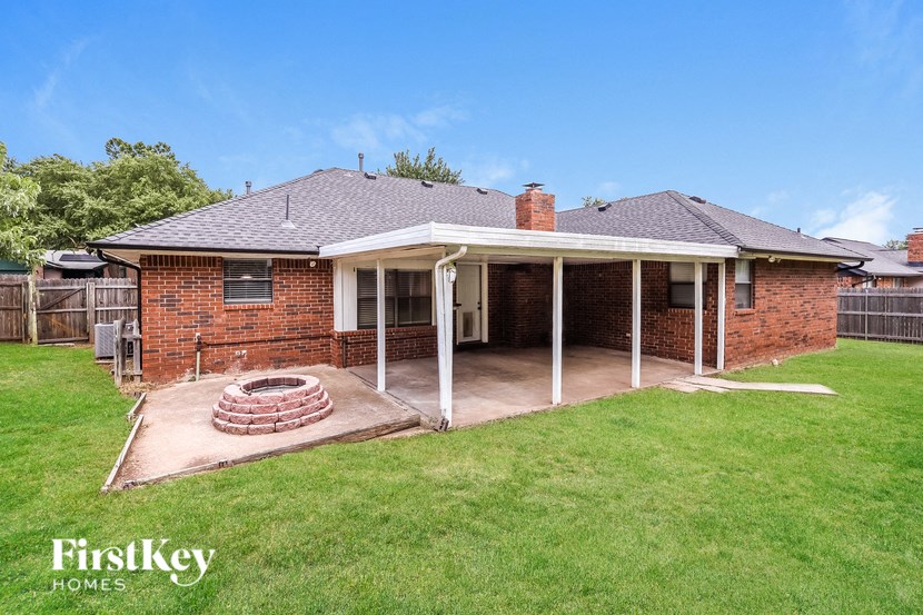 a backyard with a patio and a brick house