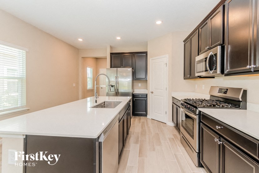 A kitchen with a white counter top and black cabinets.