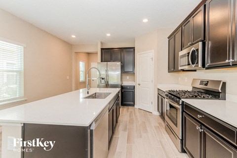 A kitchen with a white counter top and black cabinets.