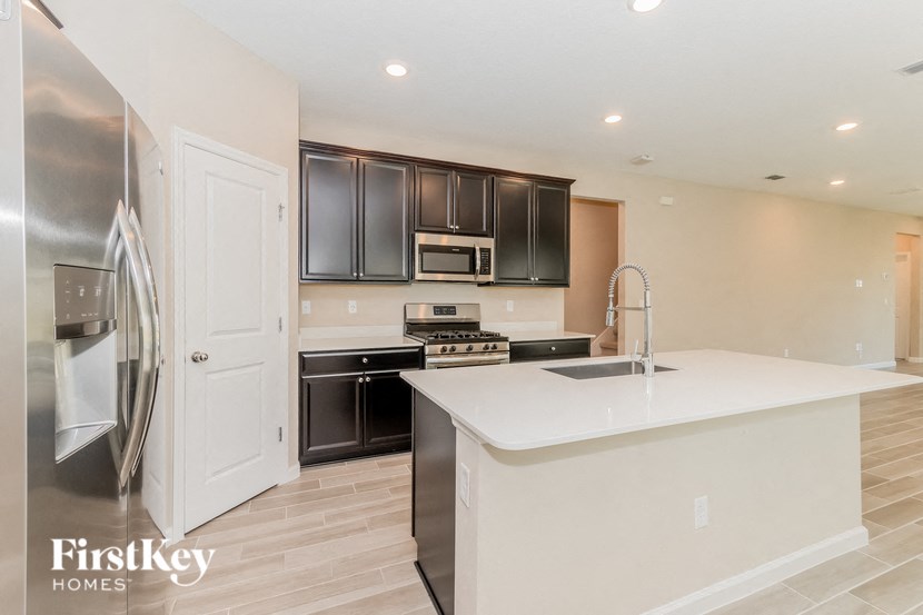 A modern kitchen with a white countertop and stainless steel appliances.