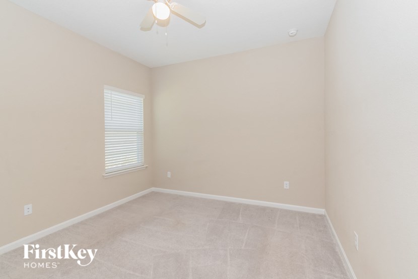 A room with a fan and a window.