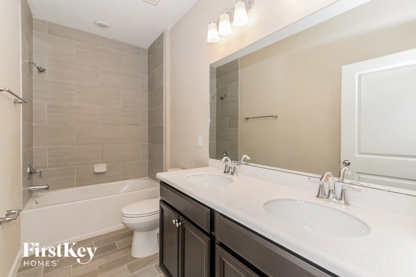 A bathroom with a white sink and a toilet.