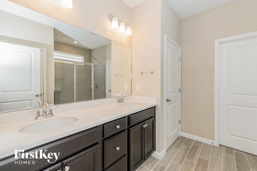 A bathroom with a sink, mirror, and a white door.
