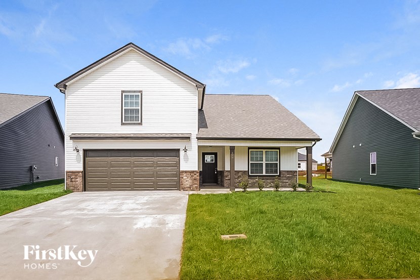 a white house with a garage and a green lawn