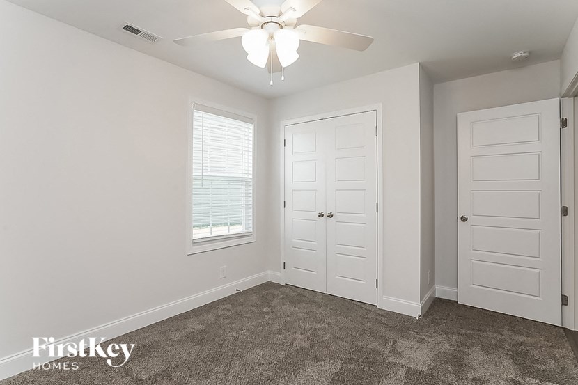a bedroom with a ceiling fan and a closet