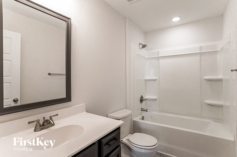 a white bathroom with a sink toilet and a shower