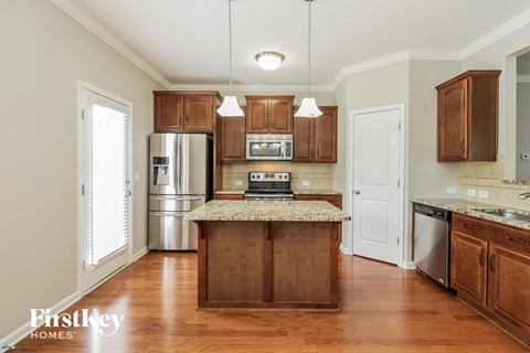 A kitchen with wooden cabinets and a granite countertop.