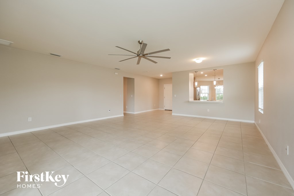 an empty living room with a ceiling fan