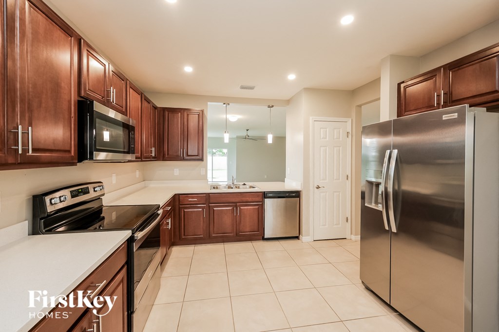 a large kitchen with stainless steel appliances and wooden cabinets