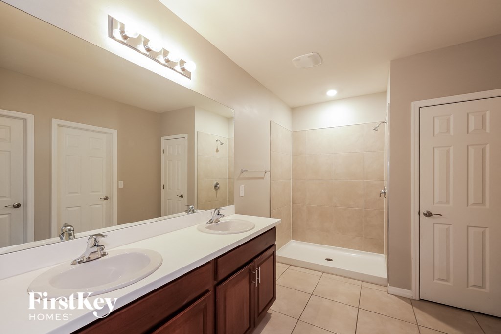 a bathroom with two sinks and a shower and a mirror