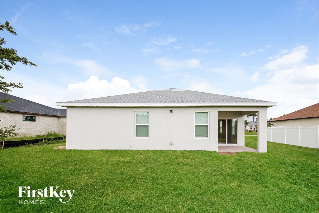 a small white house with a lawn and a blue sky