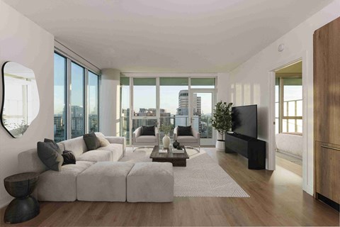 A modern living room with a large grey sofa and a wooden floor.