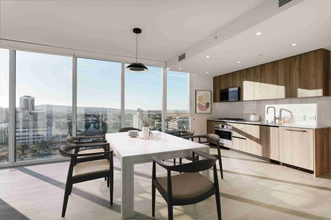 A modern kitchen with a dining table and chairs in front of a large window overlooking a cityscape.
