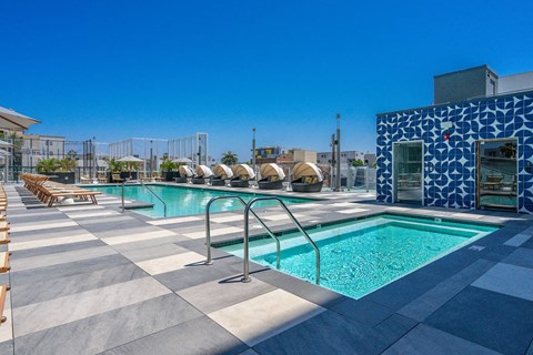 A pool with a blue tiled wall and a metal railing.