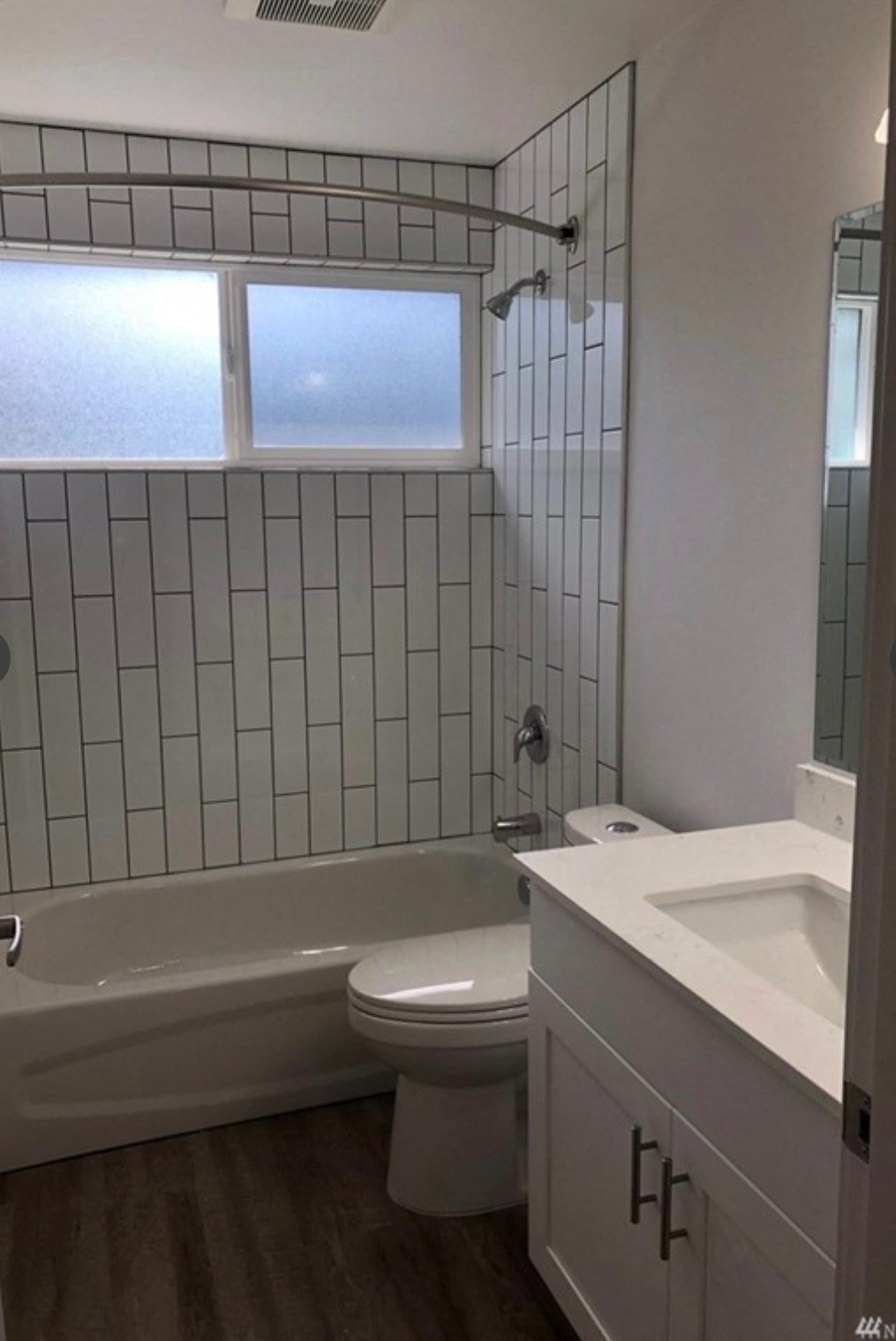 a bathroom with a toilet and a tub and a sink