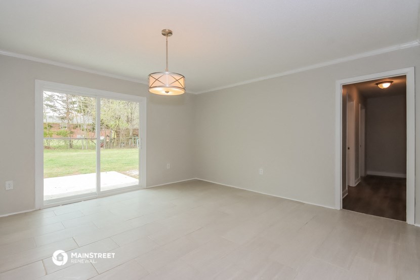 an empty living room with a door to the backyard
