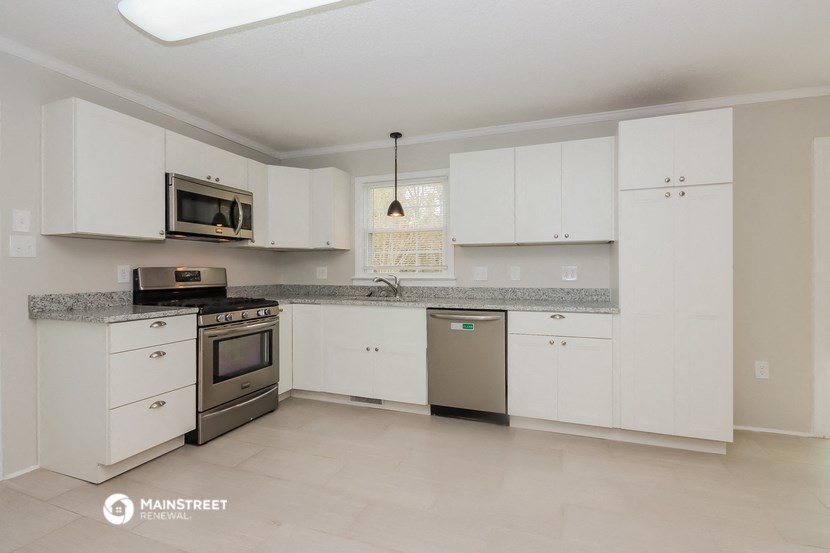 a kitchen with white cabinets and stainless steel appliances