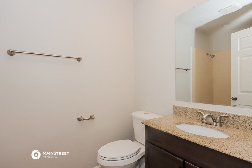 a bathroom with a toilet and a sink and a mirror