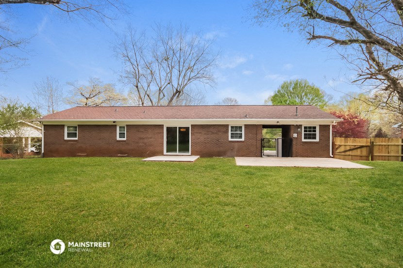 a brick house with a yard and a wood fence