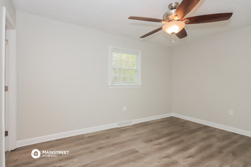 a bedroom with a ceiling fan and a window