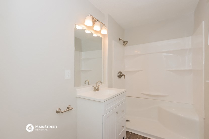 a bathroom with a sink and a tub and a mirror