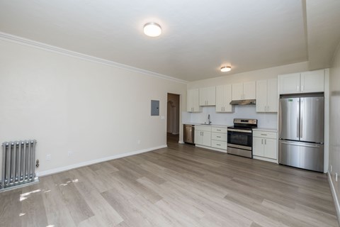 A kitchen with white cabinets and a refrigerator.