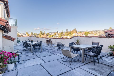 A patio with a table and chairs overlooking a cityscape.