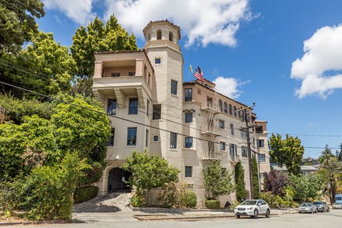 A large beige building with a tower and a flag on top.