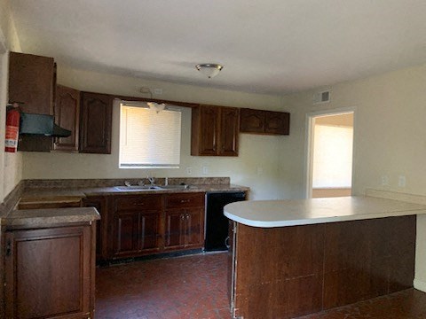 an empty kitchen with wooden cabinets and a white counter top