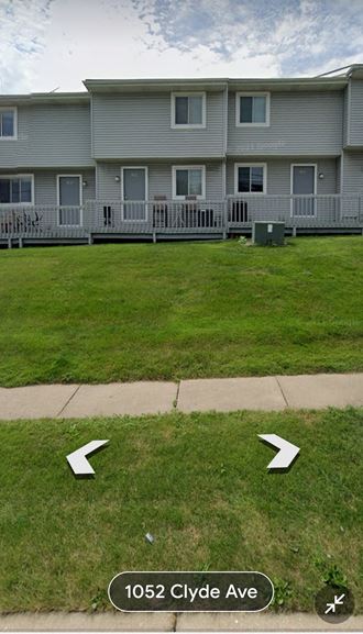 a house with two arrows in the grass in front of it