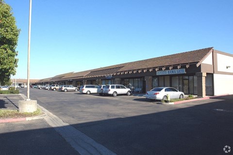 a building with cars parked outside of it in a parking lot