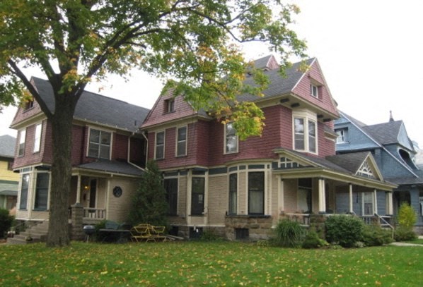 a red house with a tree in front of it