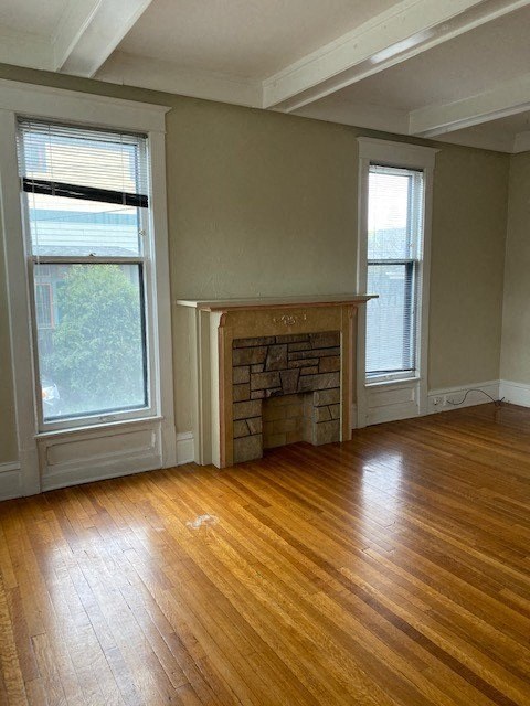 an empty living room with a fireplace and wooden floors