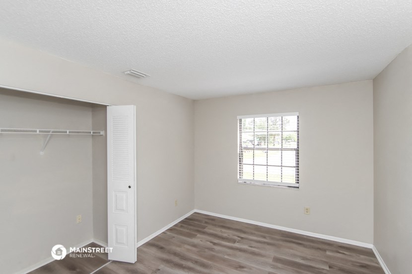 a bedroom with a door to a closet and a window