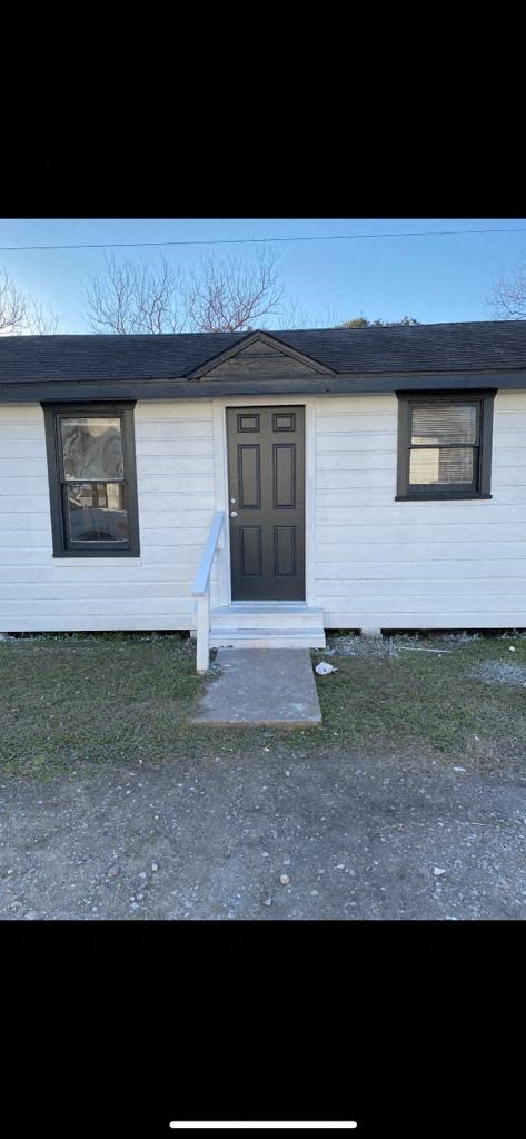 a small white house with a brown door and windows