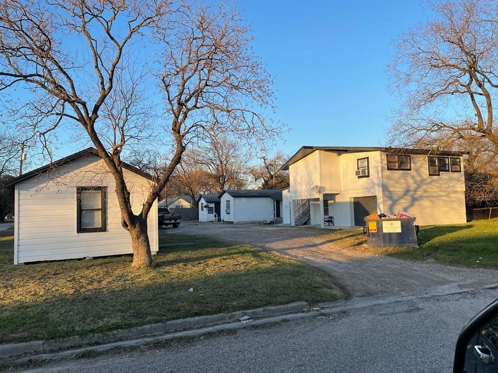 a house and a tree in front of a street