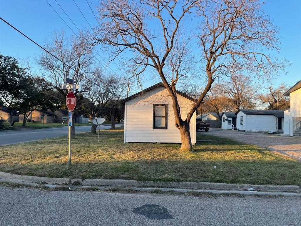 a house on the corner of a street next to a stop sign