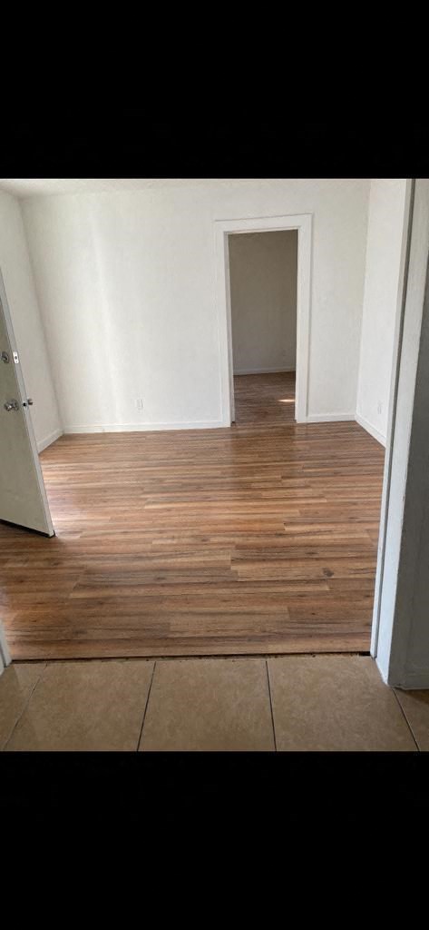 an empty room with wooden floors and a doorway
