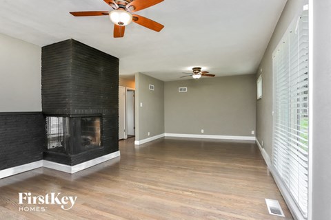 a living room with a fireplace and a ceiling fan