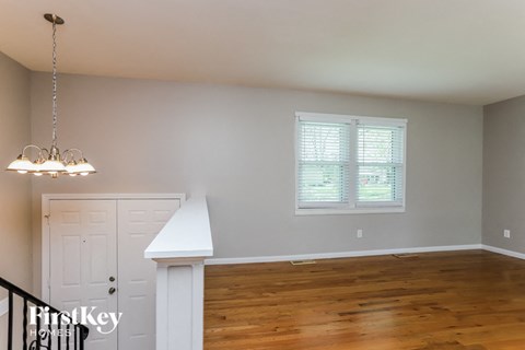 a living room with a staircase and a window and a wood floor